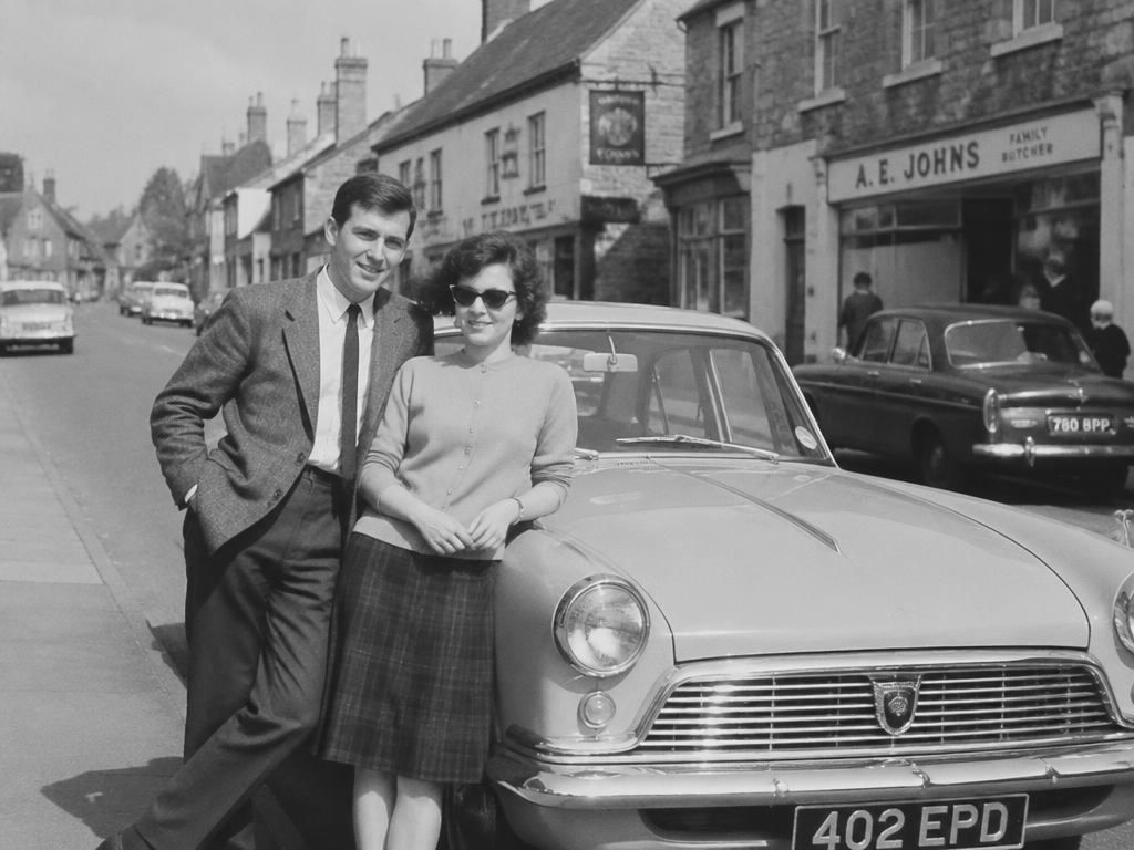 Before: black and white photograph of a family standing outside a house in the 1950s